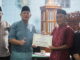 Syafrizal saat menyerahkan bantuan.