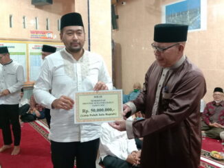 Wagub Audy Joinaldy saat menyerahkan bantuan.