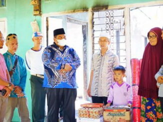 Bupati Padang Pariaman Suhatri Bur (pakai masker) usai menyerahkan santunan dan bantuan berbincang dengan keluarga yang tertimpa musibah kebakaran rumah di Paguah Duku Kurai Taji.