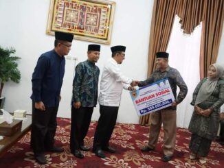 Bupati Eka Putra menyerahkan bantuan.