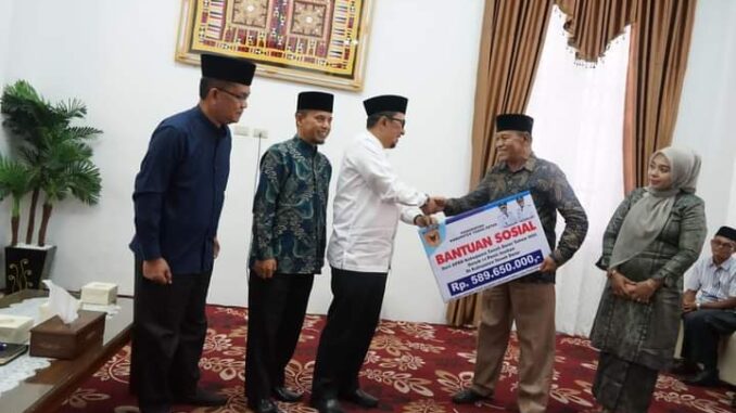 Bupati Eka Putra menyerahkan bantuan.