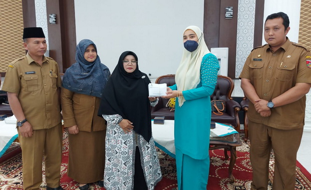 Ny.Piona Erman Safar menyerahkan bantuan kepada warga Kota Bukittinggi yang terlibat hutang kepada rentenir.