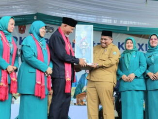 Dengan didampingi Ketua TP PKK Ny. Yusrita Suhatri Bur, Bupati Padang Pariaman Suhatri Bur menerima trofi Juara Umum lomba dari Gubernur Sumbar H. Mahyeldi.