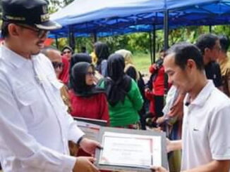 Wako Bukittinggi Erman Safar tengah menyerahkan dan menanam bibit tanaman buah buahan secara simbolis.