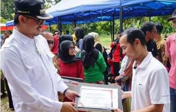 Wako Bukittinggi Erman Safar tengah menyerahkan dan menanam bibit tanaman buah buahan secara simbolis.