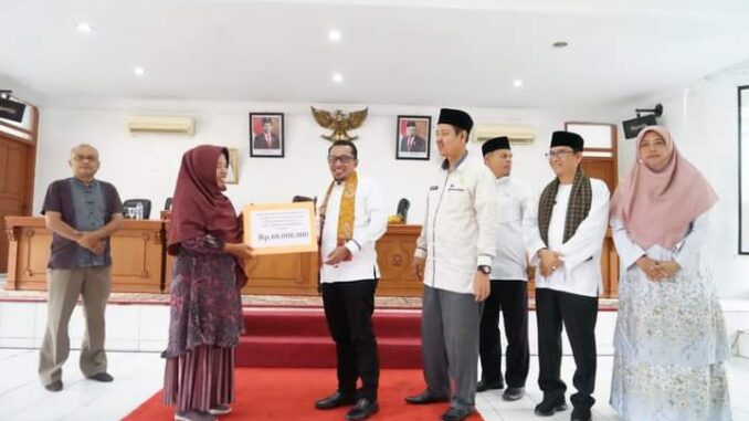 Bupati Eka Putra saat memberikan bantuan