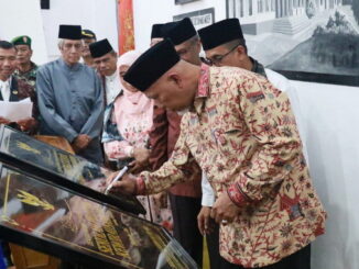 Gubernur Mahyeldi saat memaraf prasasti.
