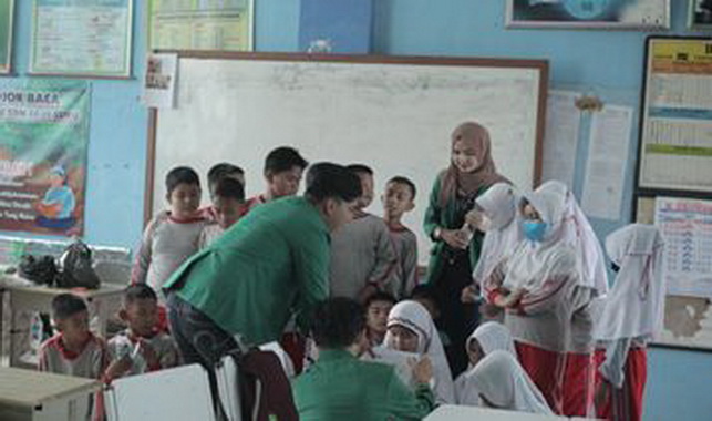 Mahasiswa Unand saat mengajarkan murid SD mengolah sampah plastik.