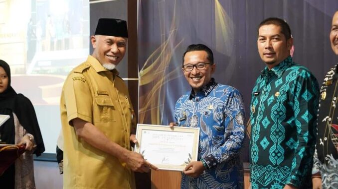 Gubernur Sumbar Mahyeldi Ansharullah menyerahkan penghargaan kepada Bupati Eka Putra