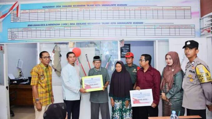 Keluarga Penerima Manfaat menerima Bantuan Langsung Tunai disaksikan oleh Wali Kota Sawahlunto