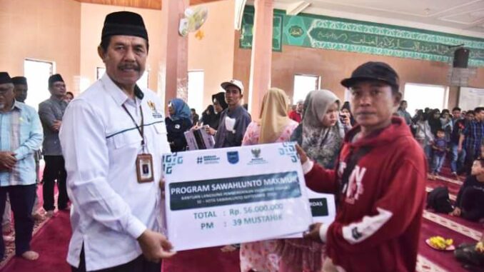 Ketua BAZNas Kota Sawahlunto, Edrizon Effendi saat serahkan Penyaluran Zakat Tahap III