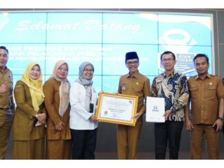 Bupati Safaruddin saat menerima penghargaan dari perwakilan Kepala Ombudsman RI Yefri Heriani.