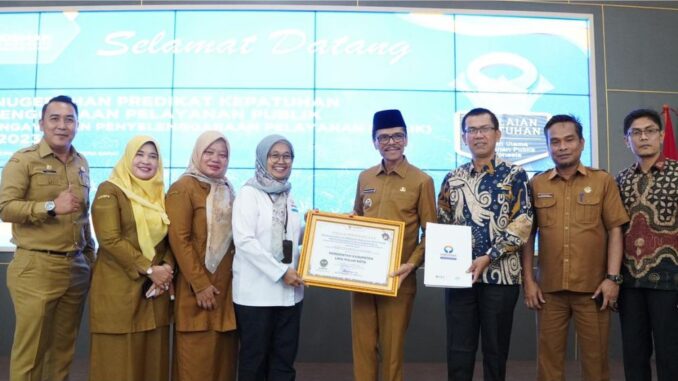 Bupati Safaruddin saat menerima penghargaan dari perwakilan Kepala Ombudsman RI Yefri Heriani.