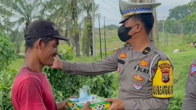 Kasat Lantas Polres Batu Bara saat membagikan nasi kotak.