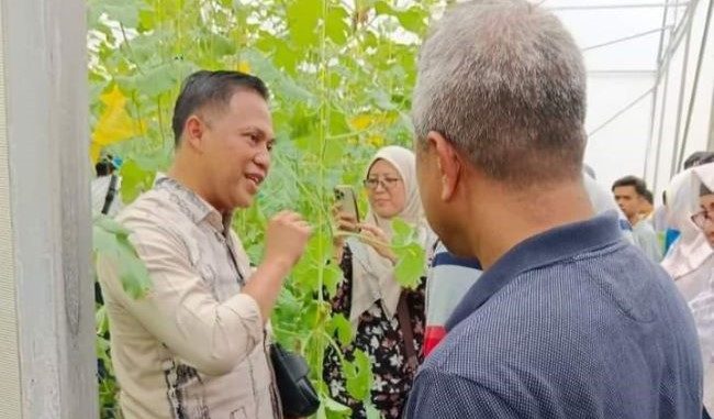 Tuan H. Abu Bakar Kepala SMK Mambau Seremban Negeri Sembelan Malaysia berbincang dengan Kepala SMKN 2 Batusangkar Budi Dharmawan saat memetik Melon di Green Hosse SMKN 2 Batusangkar.