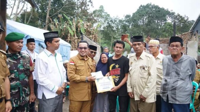 Husni Rafiah menerima bantuan dari Bupati Eka Putra.