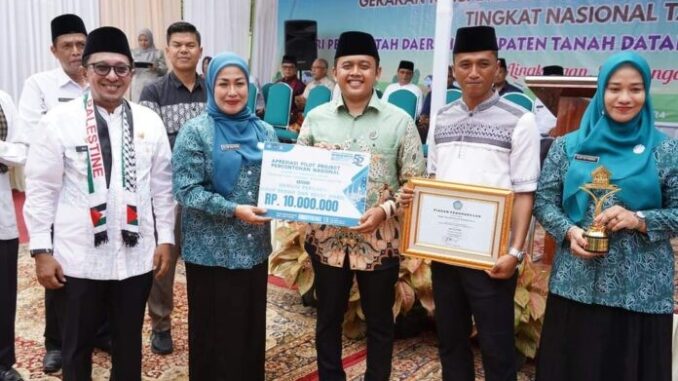 Bupati Tanah Datar Eka Putra bersama Ketua TP PKK menyerahkan tropi Juara I Nasional GKSTTB untuk Nagari Tapi Selo Kecamatan Lintau Buo Utara.