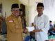 Bupati Eka Putra menyerahkan bantuan pembangunan Masjid Nikmatullah kepada pengurus masjid.