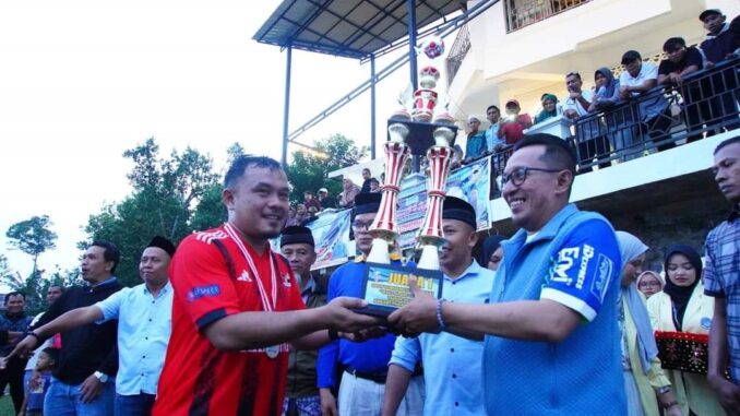 Bupati Eka Putra menyerahkan piala kepada juara I.