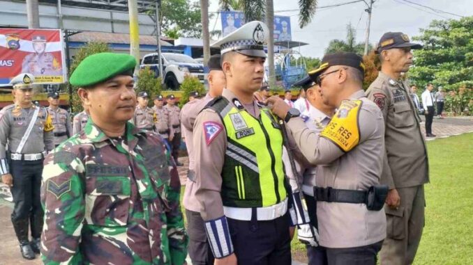 Kapolres Tanah Datar AKBP Derri Indra,S.I.K sedang memasang kokarde pelaksana operasi patuh.