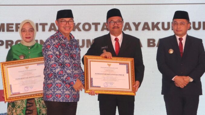 Pj Wali Kota Payakumbuh saat menerima penghargaan Indeks Pembangunan Keluarga (iBangga) dari Kepala BKKBN.