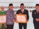 Pj Wali Kota Payakumbuh saat menerima penghargaan Indeks Pembangunan Keluarga (iBangga) dari Kepala BKKBN.