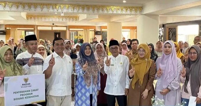 Ketua TP PKK Kota Bukittinggi menyerahkan bantuan nutrisi kepada keluarga berisiko stunting dalam kegiatan Gerakan Orang Tua Asuh Cegah Stunting (GENTING).