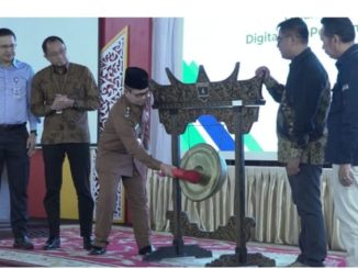 Wawako Bukittinggi Ibnu Asis memukul gong, tanda dibukanya Seminar Nasional Literasi Rupiah dan Digitalisasi di Aula Istana Bung Hatta, Senin, (22/09).