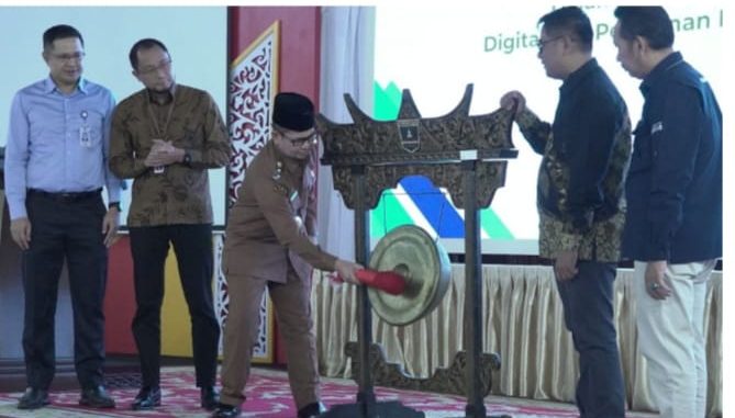 Wawako Bukittinggi Ibnu Asis memukul gong, tanda dibukanya Seminar Nasional Literasi Rupiah dan Digitalisasi di Aula Istana Bung Hatta, Senin, (22/09).