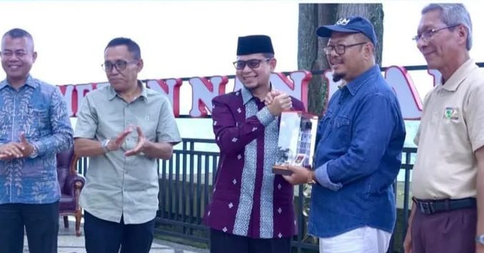 Wawako Bukittinggi Ibnu Asis menyerahkan cindera mata kepada pimpinan panitia pertemuan guru besar Perguruan tinggi Negeri berbadan Hukum yang melakukan pertemuan di Bukittinggi.