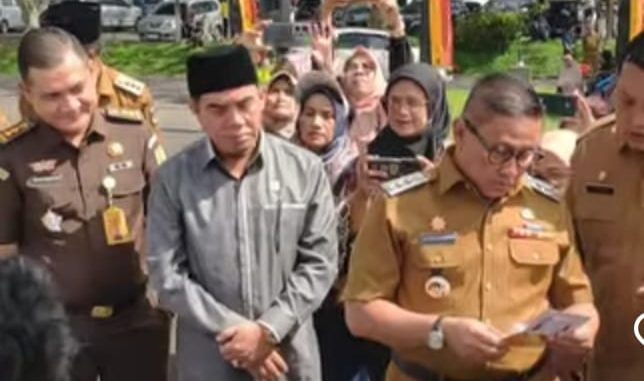 Wako Ramlan Nurmatias menyerahkan secara simbolis buku tabungan dan Kartu Keluarga Sejahtera (KKS) kepada Keluarga Penerima Manfaat dalam kegiatan launching pendistribusian bansos.