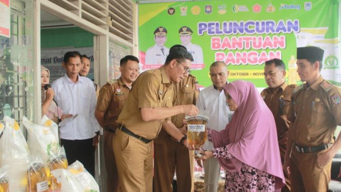 Asisten II Setda Payakumbuh menyerahkan bantuan pangan cadangan beras pemerintah (CPP) dan minyak goreng kepada warga Kelurahan Balai Jariang.