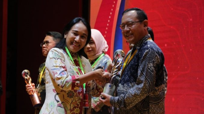 Sekretaris Utama BIG, Belinda Arunarwati Margono saat menyerahkan penghargaan Bhumandala Rajata kepada Wali Kota Payakumbuh Zulmaeta pada ajang Inovasi Geospasial Tahun 2025.