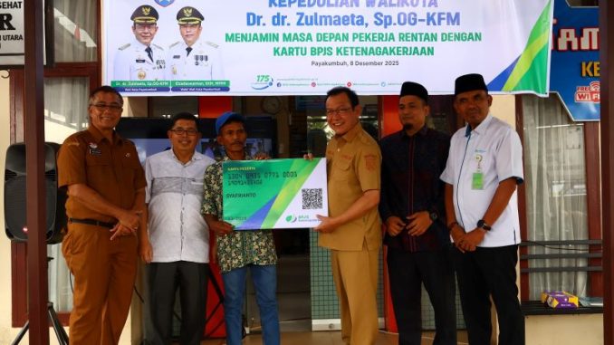 Wako Zulmaeta menyerahkan kartu BPJS Ketenagakerjaan secara simbolis kepada pekerja rentan di Kelurahan Napar.